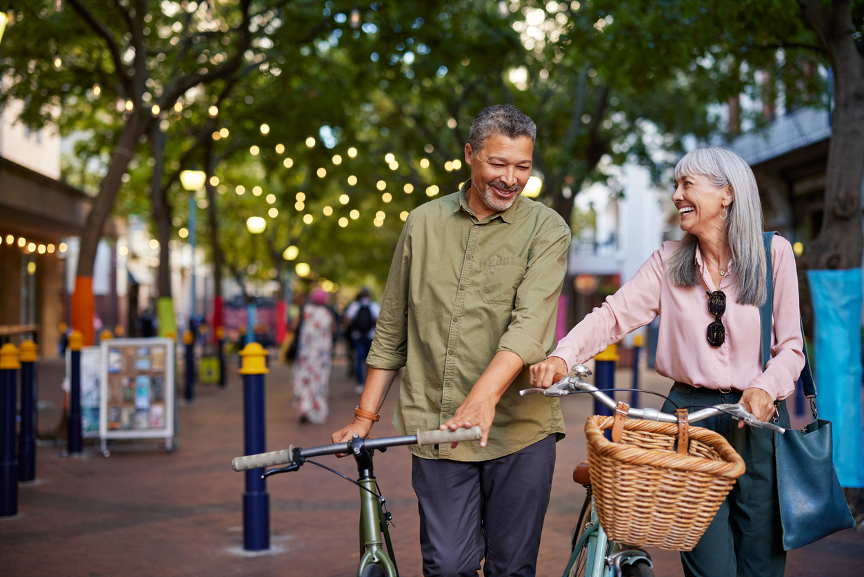 Senior couple cycling in a city street while talking